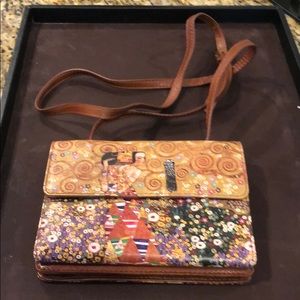 Icon wallet with adjustable shoulder strap.